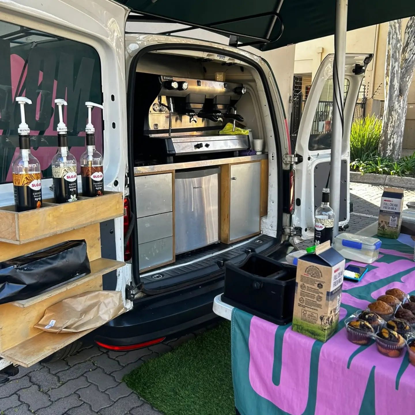 Inside the MO'BA van, showing the built-in espresso machine, fridge and flavoured syrup station.